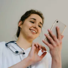 the girl doctor smiles looking at smartphone