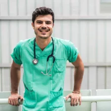 young doctor smiling and posing in green scrubs with stethescope