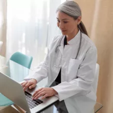 medical specialist working on laptop at office