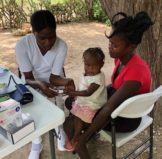 Haiti nurse helping patient