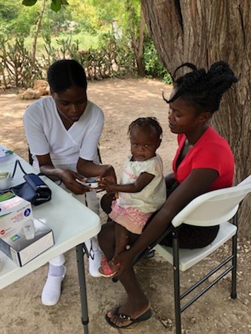 Haiti nurse helping patient